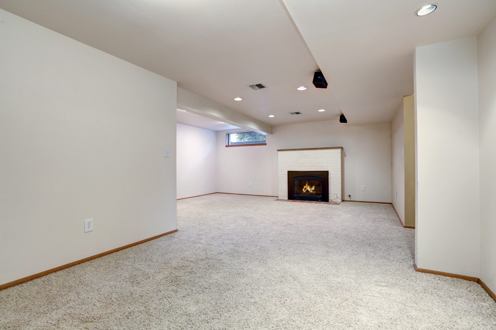 White empty basement room with fireplace and wall to wall carpet floor. Northwest, USA